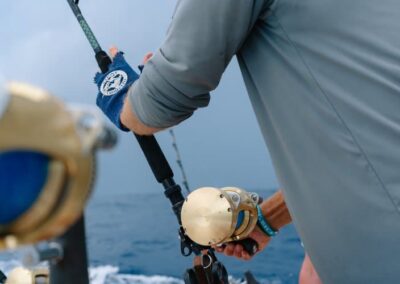 An image of an angler reeling in a fish on an Ocean Fox charter