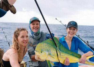 An image of guests with a beautiful mahi mahi on an Ocean Fox fishing charter.