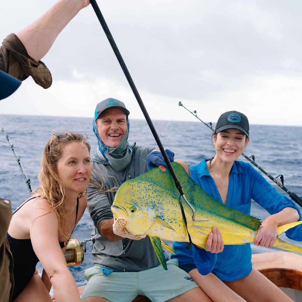 An image of guests with a beautiful mahi mahi on an Ocean Fox fishing charter.