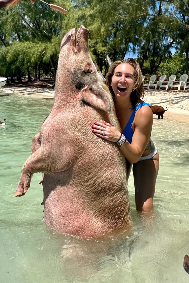 An image of a guest with a big pig at Pig Beach Bahamas