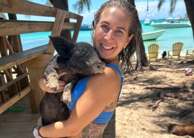 An image of a guest with a cute piggy on Pig Beach in the Bahamas with Ocean Fox Charters